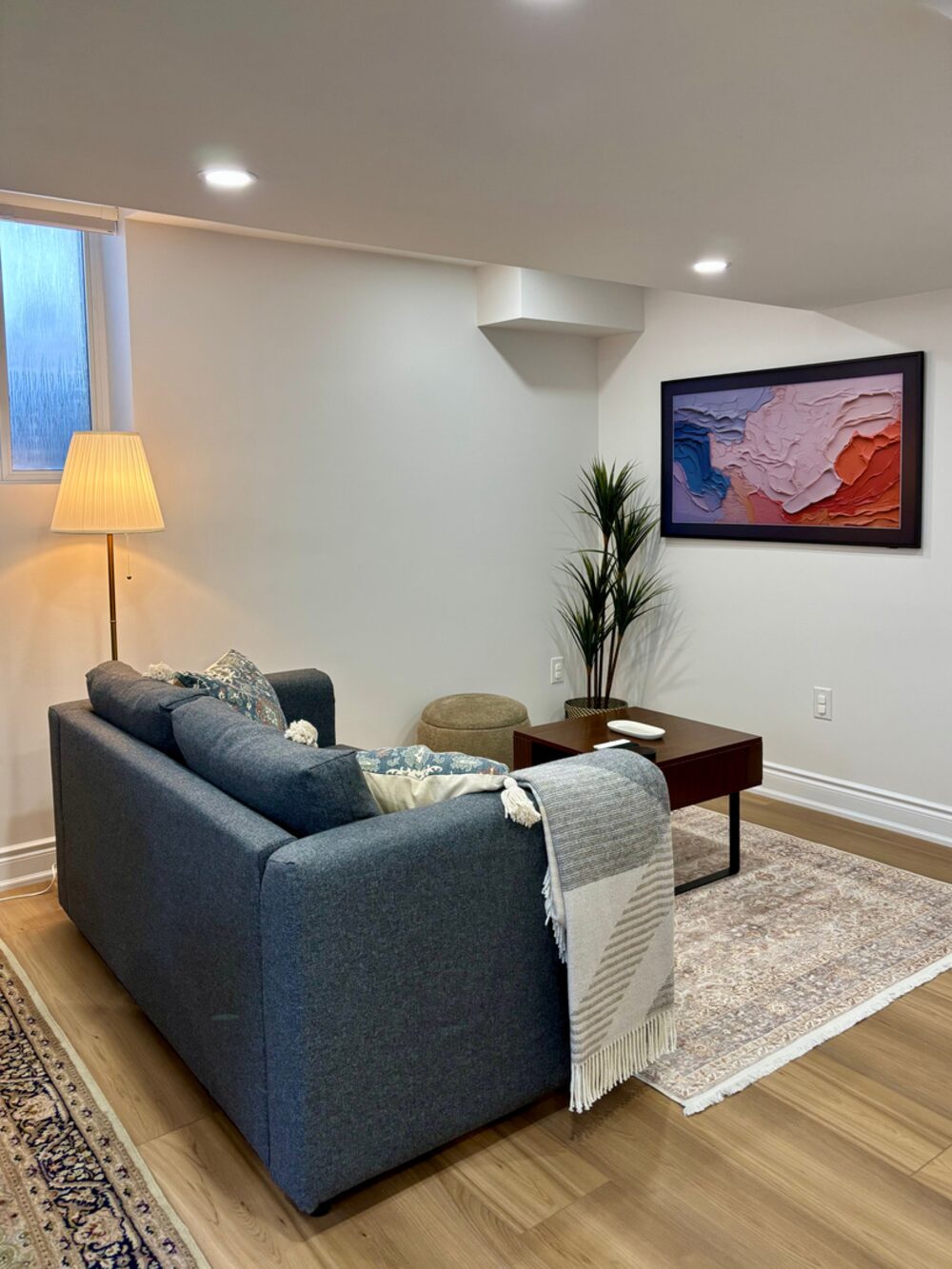 Living room of the 2 Bedroom Guest Apartment in Milton, Ontario, featuring a blue sofa and modern decor