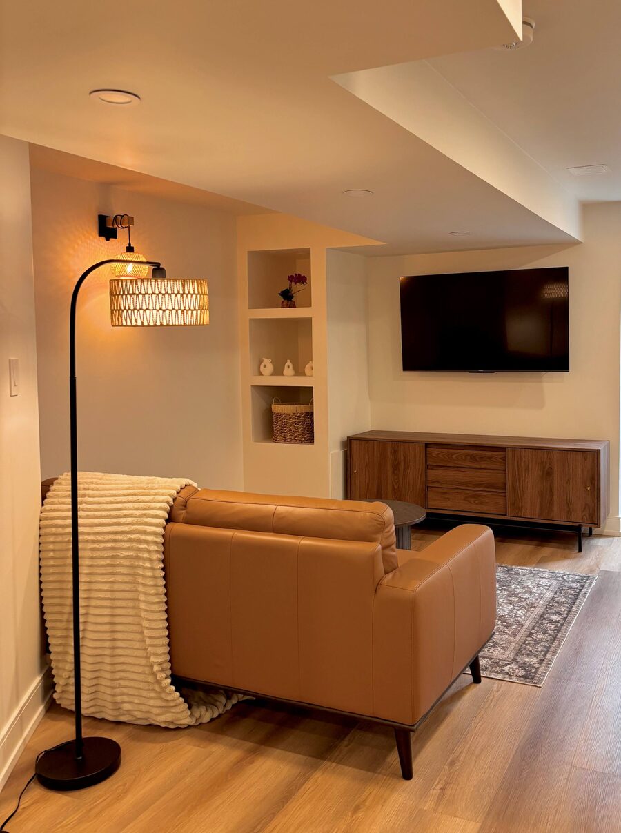 Living room of the Modern Guest Suite in Mississauga with tan leather sofa and built-in shelving